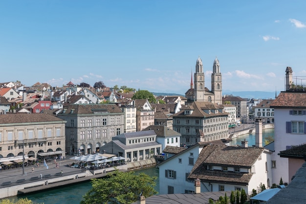 Widok z lotu ptaka na zabytkowe centrum Zurychu ze słynnym kościołem Grossmunster i rzeką Limmat z parku Lindenhof, Zurych, Szwajcaria. Letni krajobraz, słoneczna pogoda, błękitne niebo i słoneczny dzień