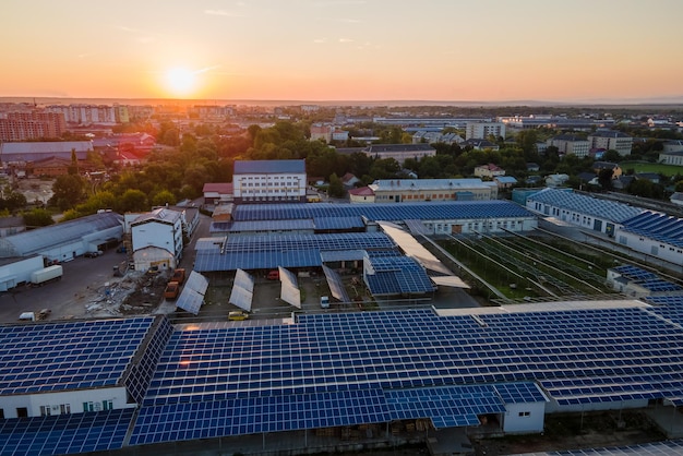 Widok z lotu ptaka niebieskich fotowoltaicznych paneli słonecznych zamontowanych na dachu budynku przemysłowego do produkcji zielonej ekologicznej energii elektrycznej Produkcja koncepcji zrównoważonej energii