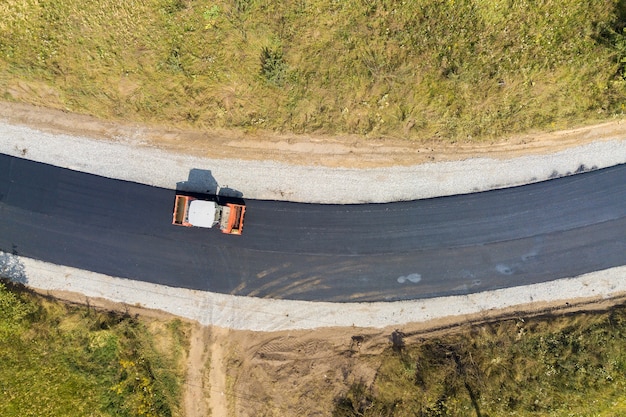 Widok z lotu ptaka nowej budowy dróg z parową maszyną rolkową w pracy.