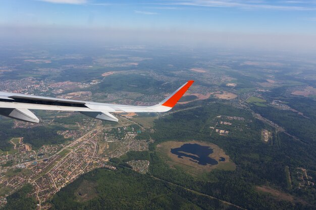 Widok z lotu ptaka obłoczny niebieskiego nieba i samolotu skrzydła widok przez samolotowego okno.