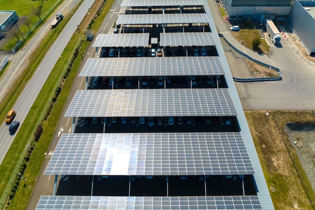 Widok z lotu ptaka paneli słonecznych zainstalowanych jako zacieniony dach nad parkingiem z zaparkowanymi samochodami w celu efektywnego wytwarzania czystej energii elektrycznej Technologia fotowoltaiczna zintegrowana z infrastrukturą miejską