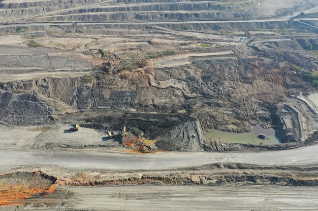 Widok z lotu ptaka przemysłowego górnictwa odkrywkowego z dużą ilością maszyn w pracy - widok z góry.