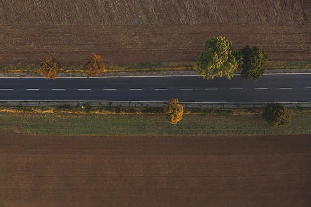 Widok z lotu ptaka ruchu na dwupasmowej drodze przez wieś i pola uprawne jesienią