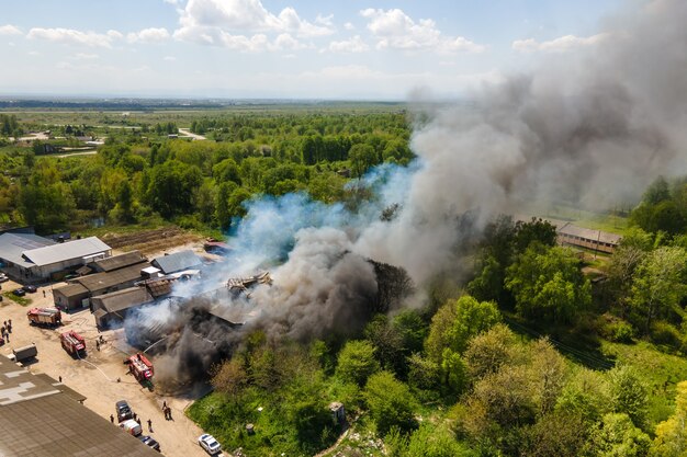 Widok Z Lotu Ptaka Strażaków Gaszących Zniszczony Budynek W Ogniu Z Zawalonym Dachem I Unoszącym Się Ciemnym Dymem.