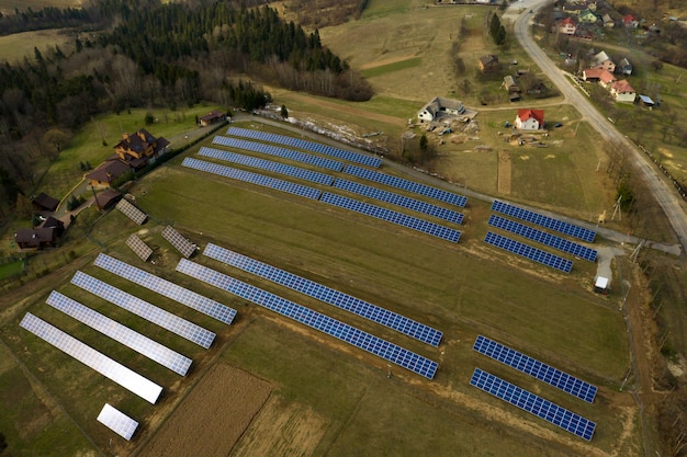 Zdjęcie widok z lotu ptaka wielkiego pola słonecznego systemu fotowoltaicznego paneli systemu produkującego odnawialną czystą energię na zielonej trawy tle.