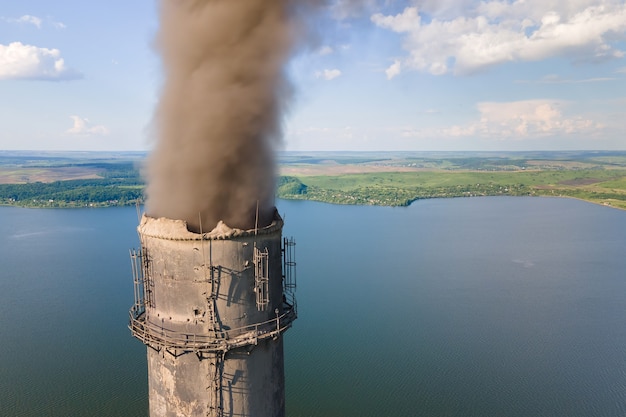 Widok z lotu ptaka wysokich rur elektrowni węglowej z czarnym kominem zanieczyszczającym atmosferę. Produkcja energii elektrycznej z koncepcją paliw kopalnych.