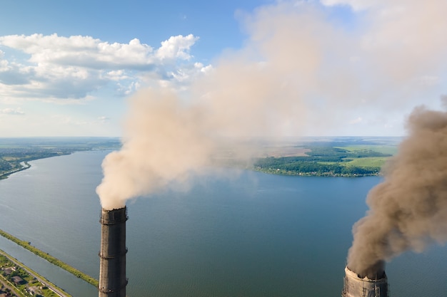 Widok z lotu ptaka wysokich rur elektrowni węglowej z czarnym kominem zanieczyszczającym atmosferę. Produkcja energii elektrycznej z koncepcją paliw kopalnych.