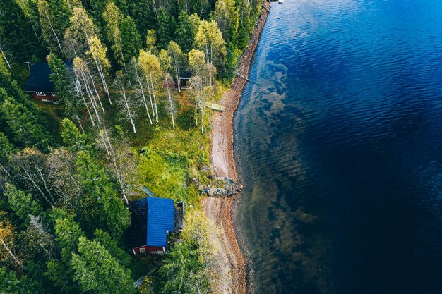 Widok z lotu ptaka z bali lub domku z sauną w wiosennym lesie nad jeziorem w wiejskiej Finlandii