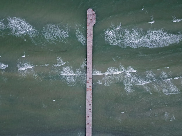 Widok z lotu ptaka z drona na molo nad morzem w pochmurną pogodę na zewnątrz