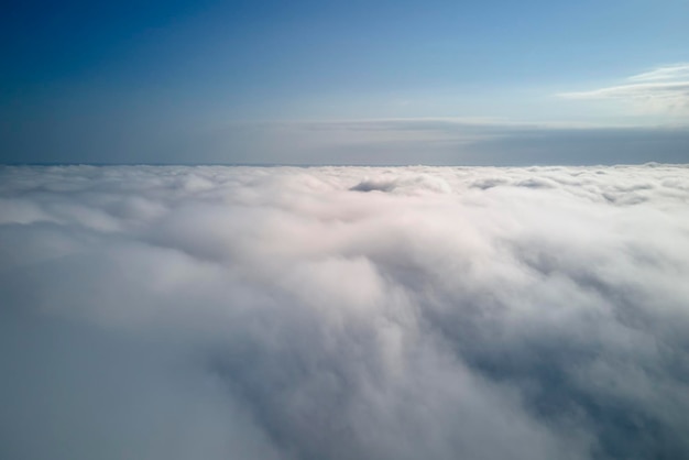 Widok z lotu ptaka z dużej wysokości ziemi pokrytej puszystymi deszczowymi chmurami tworzącymi się przed burzą
