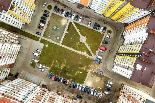 Widok Z Lotu Ptaka Zaparkowanych Samochodów Na Parkingu Między Wysokimi Apartamentowcami.