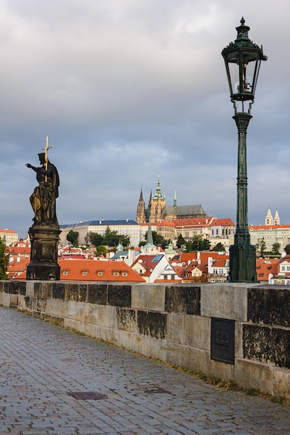 Widok z Mostu Karola na Zamek Praski w pochmurną pogodę. Historyczny punkt orientacyjny na starym mieście w Pradze. Starożytna architektura gotycka w stolicy Czech.