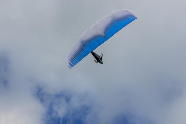 Zdjęcie widok z niskiego kąta na ludzi latających paragliderem na niebie