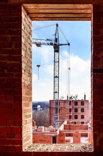 Widok z okna na plac budowy z żurawiem wieżowym