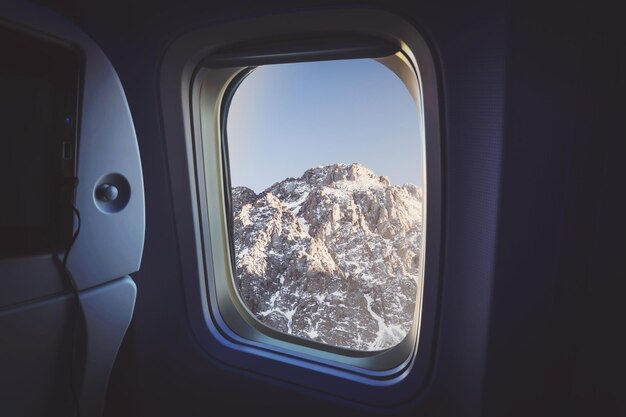 Widok z okna samolotu Na zewnątrz widać śnieżne drzewo i zachód słońca