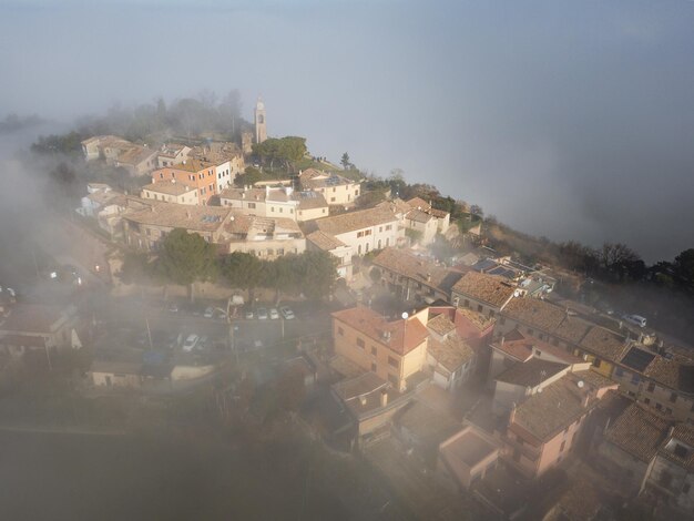 Widok z powietrza Fiorenzuola di Focara zanurzona w mgle we Włoszech