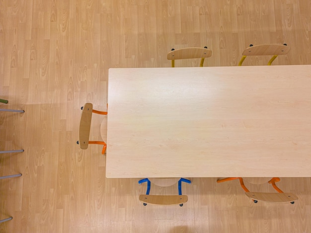 Zdjęcie widok z powietrza klasy szkolnej z brązowymi krzesłami i stołami