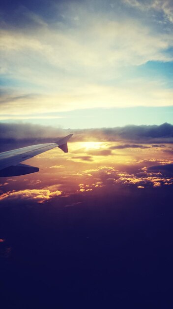 Zdjęcie widok z powietrza na chmury nad samolotem przy zachodzie słońca