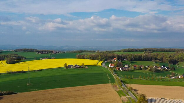 Zdjęcie widok z powietrza z drona na żółte pola rzepaków na niemieckiej wsi