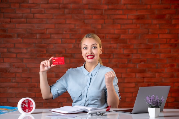 widok z przodu biura podróży trzymającego czerwoną kartę kredytową asystent globalny menedżer pieniądze praca zawód agencja pracy profesjonalista