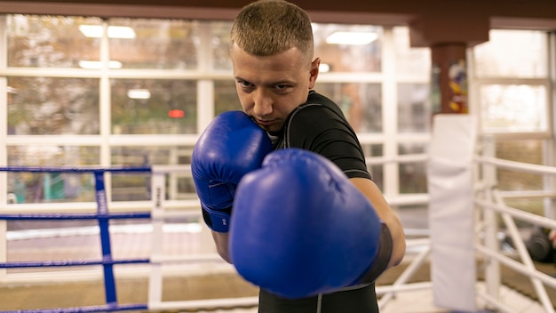 Zdjęcie widok z przodu ćwiczącego boksera w rękawiczkach