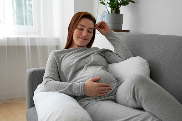 Zdjęcie widok z przodu kobieta w ciąży relaks w domu