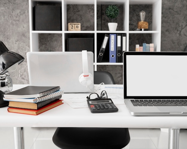 Widok z przodu laptopów z notebookami i kalkulatorem na biurku