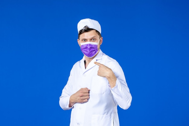 Widok z przodu lekarza w garniturze i fioletowej masce na niebiesko