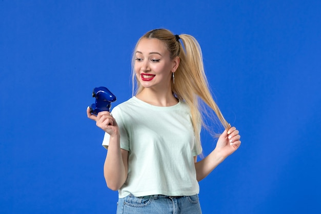 widok z przodu młoda kobieta grająca w grę wideo z gamepadem na niebieskim tle młodzieżowy joystick dorosły radosny zwycięski gracz online wideo