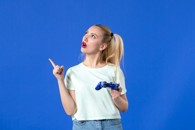 widok z przodu młoda kobieta z gamepadem na niebieskim tle młodzieżowy joystick wideo online radosny wygrywający wirtualny dorosły gracz