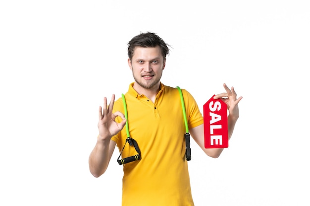 widok z przodu młody mężczyzna z ekspanderem trzymający sprzedaż napisany tabliczka znamionowa na białym tle praca kolor sport pracownik ludzki zakupy sprzedawca shopping