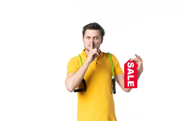 widok z przodu młody mężczyzna z ekspanderem trzymający sprzedaż napisany tabliczka znamionowa z prośbą o milczenie na białym tle praca kolor sport człowiek zakupy mundur sprzedawca pracownik