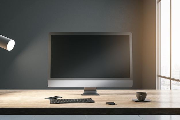 Widok z przodu na pusty czarny nowoczesny ekran monitora komputerowego z miejscem na projekt strony internetowej lub stronę internetową na nasłonecznionym drewnianym stole z klawiaturą na tle ciemnej ściany i widokiem na miasto makieta renderowania 3D