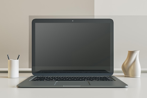 Widok z przodu na pustym ciemnym nowoczesnym ekranie monitora laptopa z miejscem do projektowania stron internetowych lub strony internetowej na białej powierzchni stołu wśród stojaka na długopisy i wazon na tle jasnej ściany Makieta renderowania 3D