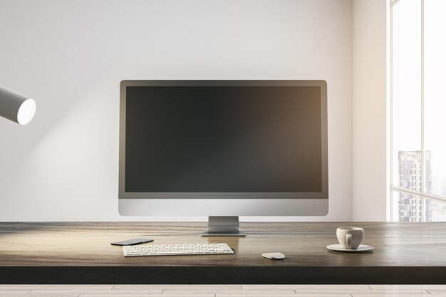 Widok z przodu na pustym ciemnym nowoczesnym monitorze komputerowym z miejscem na twoją stronę internetową lub projekt strony internetowej na drewnianym stole z filiżanką kawy i klawiaturą na jasnym tle ściany w nasłonecznionym pokoju Makieta renderowania 3D