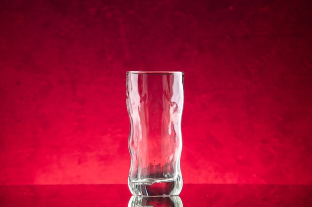 Zdjęcie widok z przodu pusta szklanka wody na czerwonym tle wolna przestrzeń
