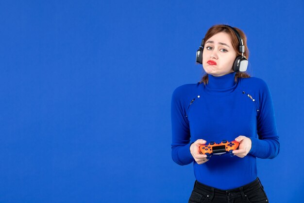 widok z przodu smutna kobieta grająca w grę wideo z gamepadem na niebieskim tle dziewczyna gracz wygrywająca młodzież wirtualna radość młoda sofa wideo dla dorosłych