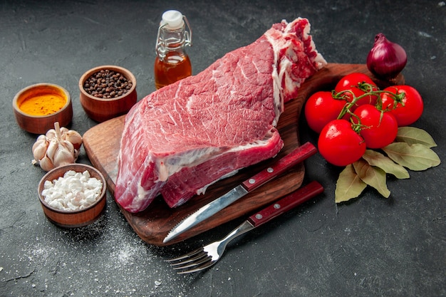 widok z przodu surowy plaster mięsa z pomidorami i przyprawami na ciemnym tle gotowanie kolor jedzenie mięso grill posiłek rzeźnik