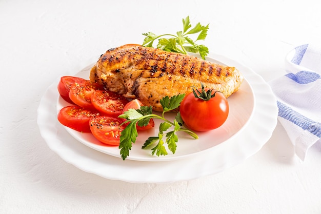 Widok z przodu talerza z soczystym grillowanym filetem z kurczaka i plasterkami pomidora pyszne zdrowe jedzenie bez gotowania w diecie olejowej