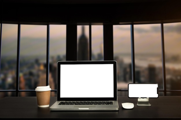 Widok z przodu z komputerowym smartfonem i tabletem na białym biurku z rozmytym tłem