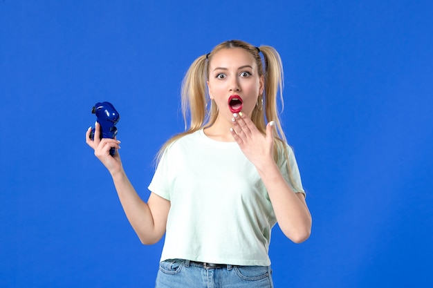 widok z przodu zszokowana młoda kobieta z gamepadem na niebieskim tle młodzieżowy joystick wideo dorosły wirtualny radosny wygrywający gracz online