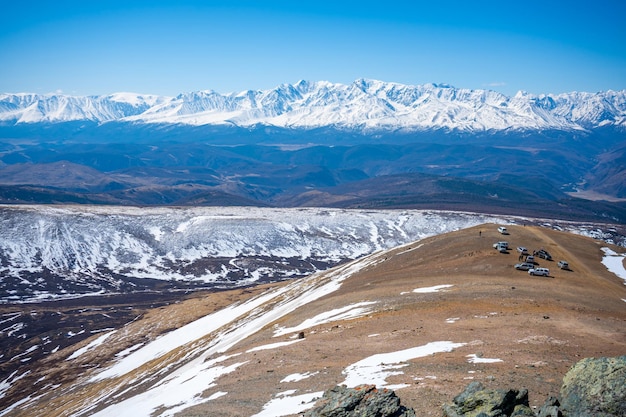 Widok z repeatera na ośnieżonych szczytach gór ałtaju samochody na szczycie góry w pobliżu miasta aktash russi