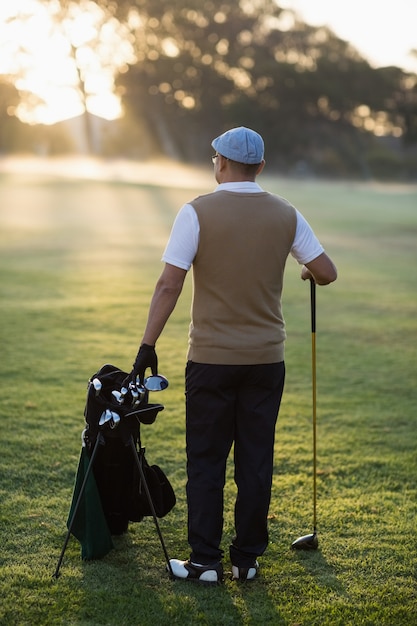 Widok z tyłu człowieka stojącego na polu golfowym