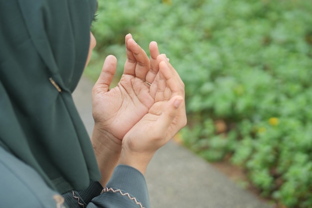 Widok z tyłu dłoni muzułmańskich kobiet modlących się w ramadanie na świeżym powietrzu