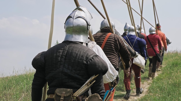 Widok z tyłu grupy średniowiecznych rycerzy idących na bitwę