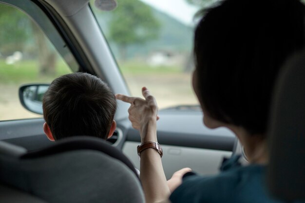 Zdjęcie widok z tyłu kobiety i chłopca podróżujących samochodem