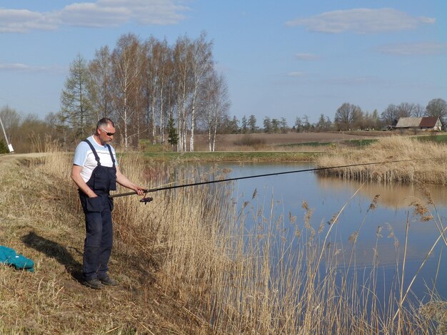 Zdjęcie widok z tyłu kobiety stojącej nad jeziorem