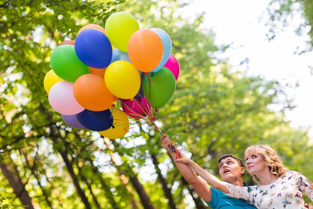 Zdjęcie widok z tyłu kobiety trzymającej balony na drzewach