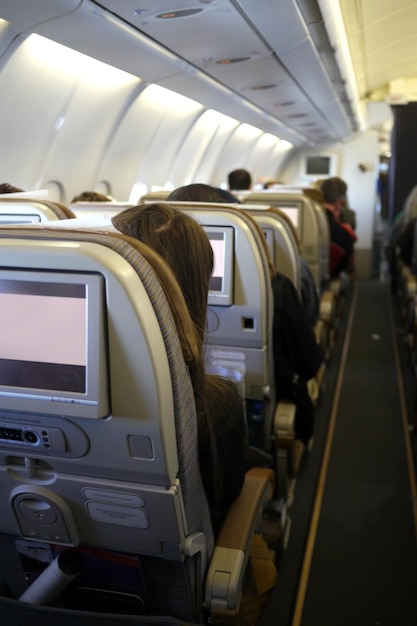 Zdjęcie widok z tyłu ludzi siedzących na fotelach w samolocie