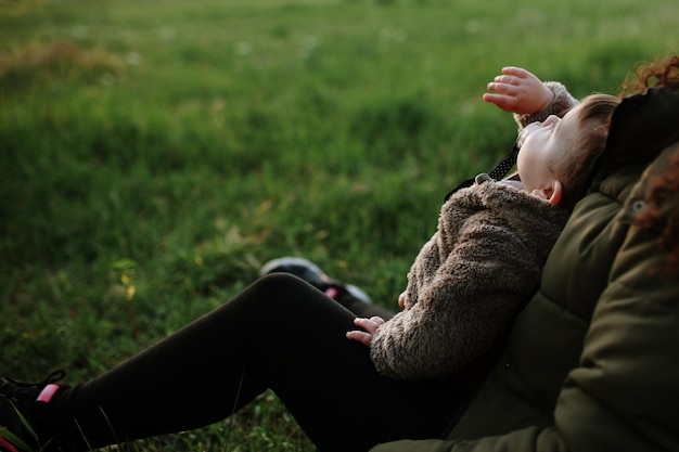 Zdjęcie widok z tyłu matki i córki na trawie na tle nieba